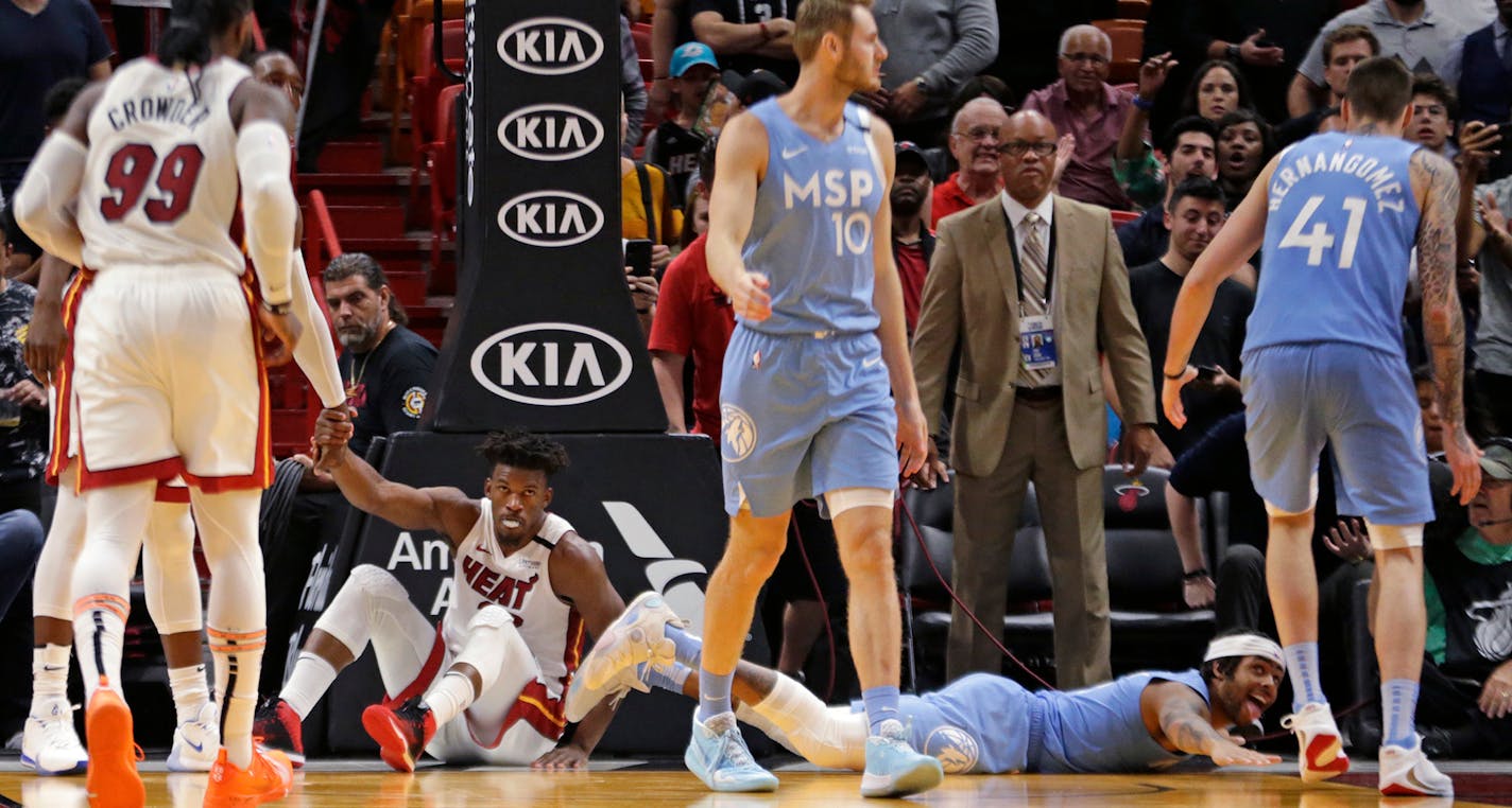 The Timberwolves' D'Angelo Russell, bottom right, reacts as the Heat's Jimmy Butler shows frustration after they both went down in the fourth quarter at the AmericanAirlines Arena in Miami