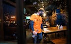 A masked employee cleaned a table at Blarney Pub & Grill in Dinkytown on Nov. 13. Hennepin County commissioners approved $8 million Tuesday to help st