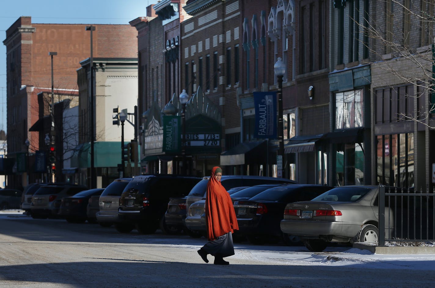 A woman walked across Central Avenue on a cold morning Wednesday in Faribault, Minn. Somali immigrants now run a restaurant, grocery and home health care business in the heart of the city.