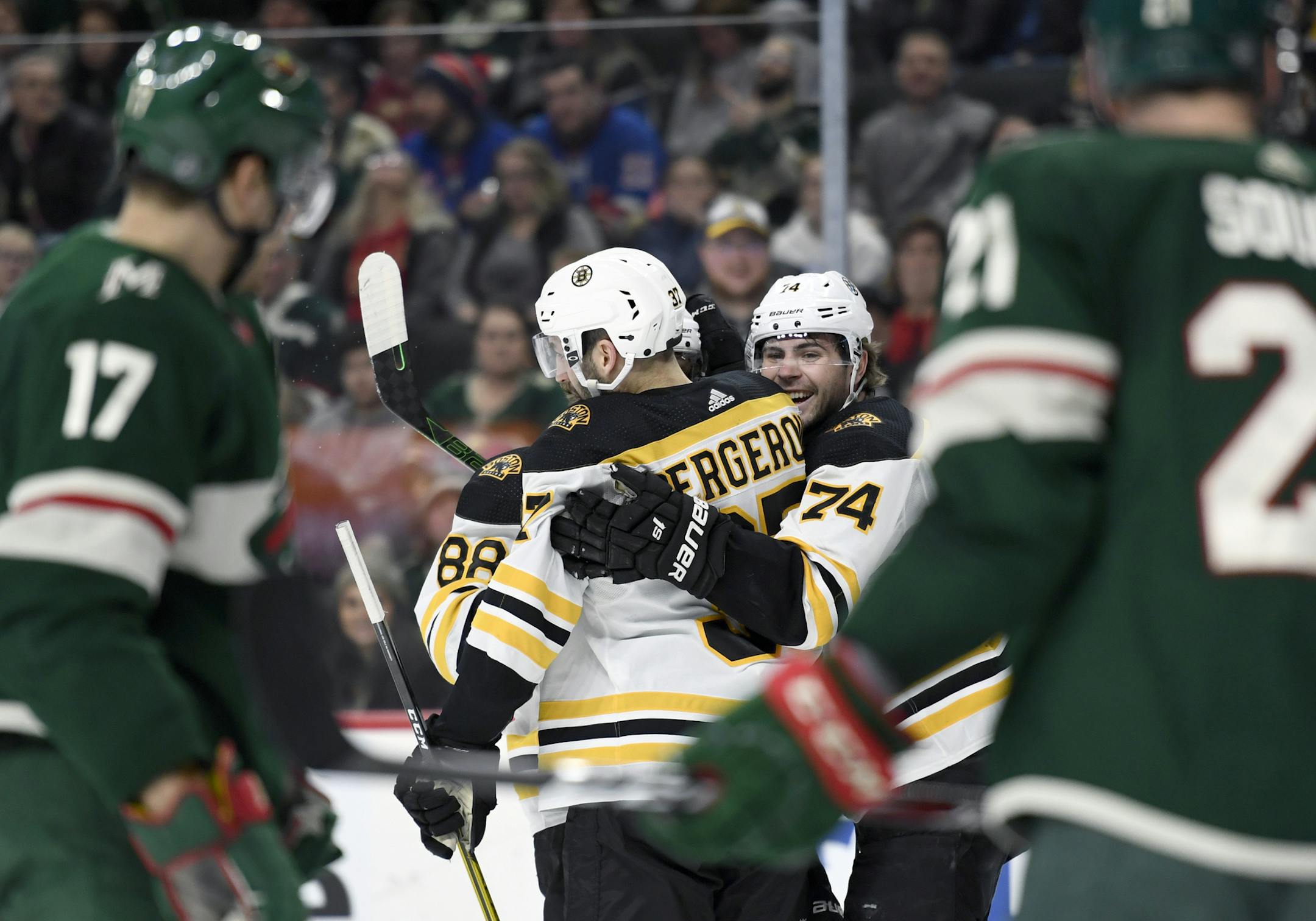 Boston Bruins' Patrice Bergeron (37) and Jake DeBrusk (74) congratulate right wing David Pastrnak (88) on a goal as the Minnesota Wild watch during the second period of an NHL hockey game Saturday, Feb. 1, 2020, in St. Paul, Minn. (AP Photo/Hannah Foslien)