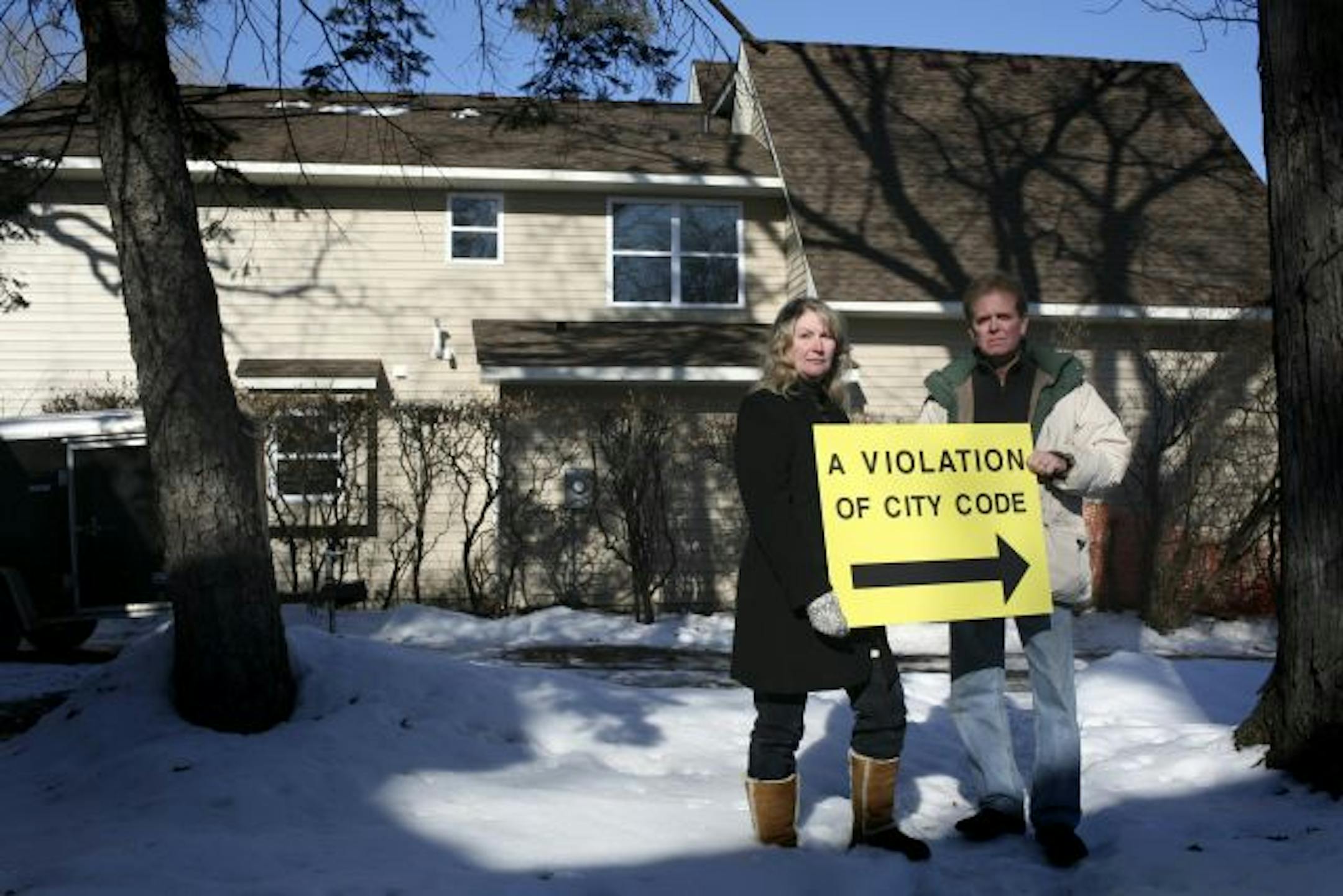 Jackie and Dick Whitbeck stood in their Edina front yard with a sign that opposes the new home construction bordering their property. The Whitbecks and their neighbors plan to put the signs in their yards.