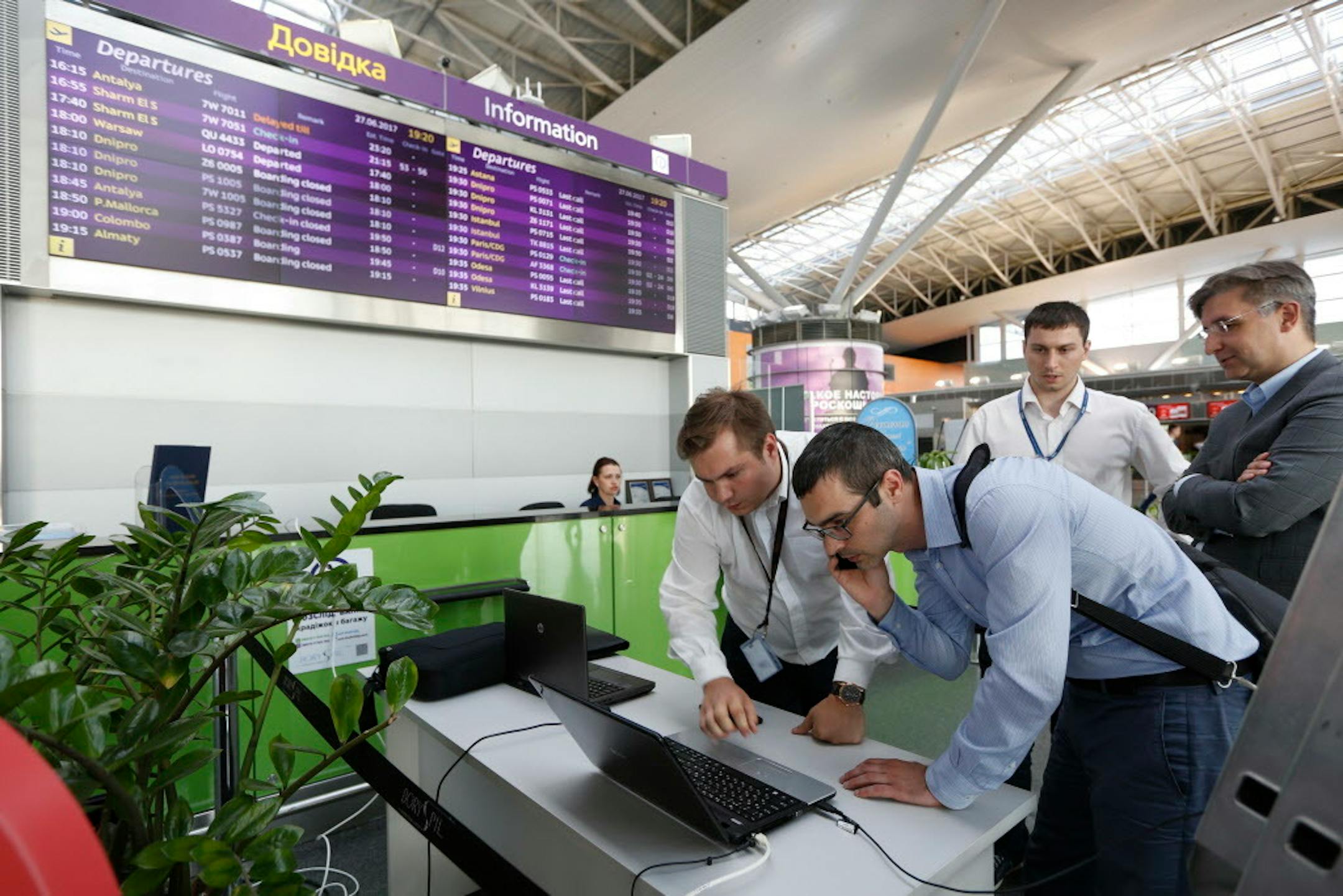 Airport employees work use a laptop computer at Boryspil airport in Kiev, Ukraine, Tuesday, June 27, 2017. A new and highly virulent outbreak of malicious data-scrambling software appears to be causing mass disruption across Europe, hitting Ukraine especially hard, with company and government officials reporting serious intrusions at the Ukrainian power grid, banks and government offices. (AP Photo/Sergei Chuzavkov)