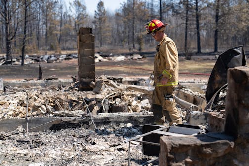 Jon Settergren, a Nisswa firefighter, surveys the smoldered remains of a structure as part of the efforts to combat the Camp House wildfire in Brimson, Minn. on Thursday, May 15, 2025.   ]

ALEX KORMANN • alex.kormann@startribune.com