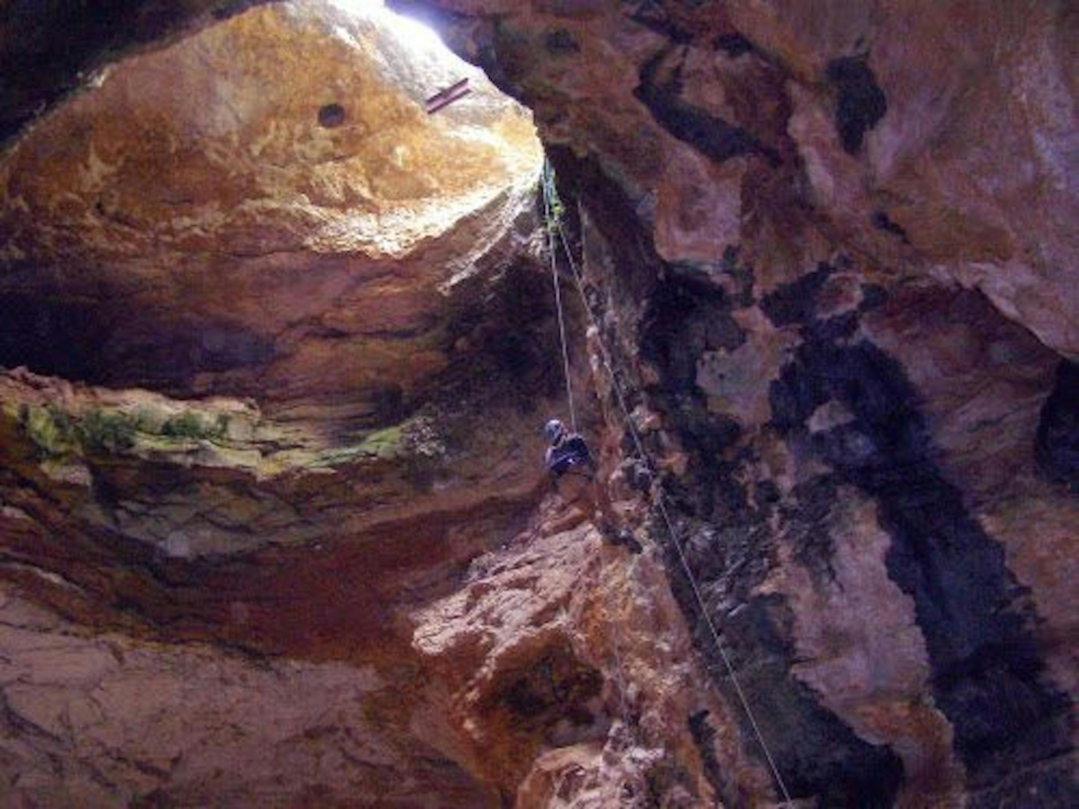 In an image provided by the Bureau of Land Management, Bureau of Land Management cave specialist Bryan McKenzie rappels into Natural Trap Cave in north-central Wyoming.