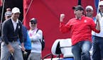 A spectator celebrates after being challenged by Europe's Justin Rose to hole a putt for one hundred dollars and holing it during practice session ahe