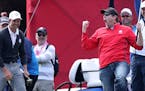 A spectator celebrates after being challenged by Europe's Justin Rose to hole a putt for one hundred dollars and holing it during practice session ahe