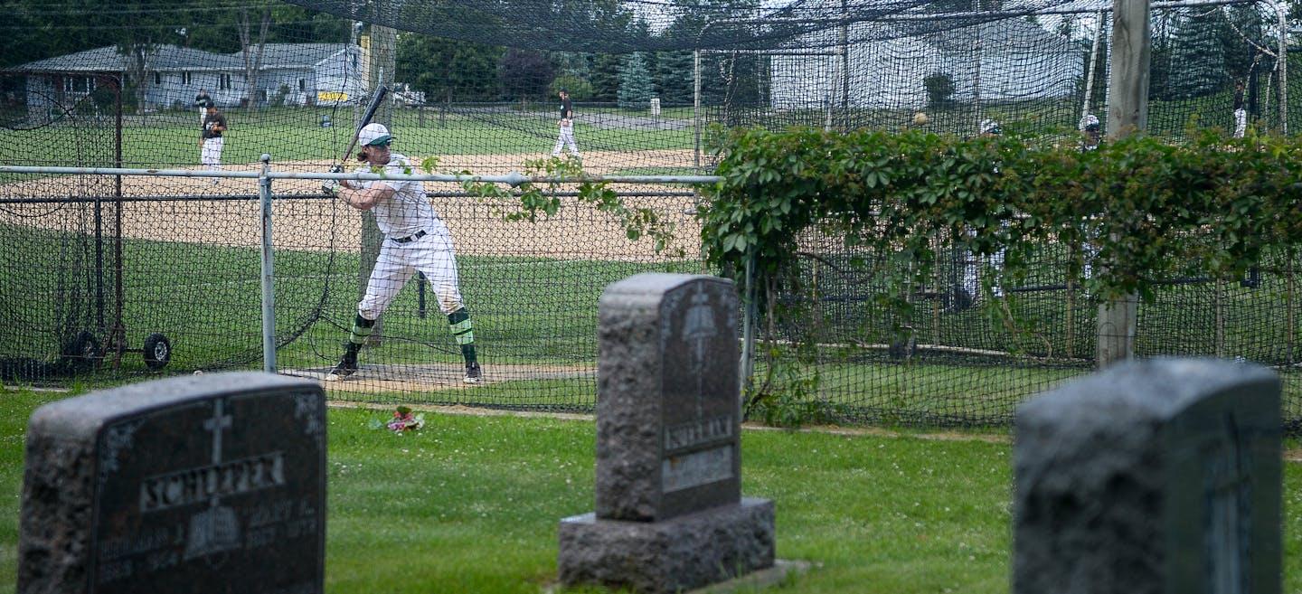 An Atwater player practiced batting in the cages at the Farming Flames Baseball field on Sunday, June 25, 2017 in Farming, Minn. The field butts up against the town&#x2019;s cemetery.