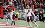 Ohio State receiver Marvin Harrison, left, scores a touchdown as Minnesota defensive back Coleman Bryson (16) defends during the second half of an NCA