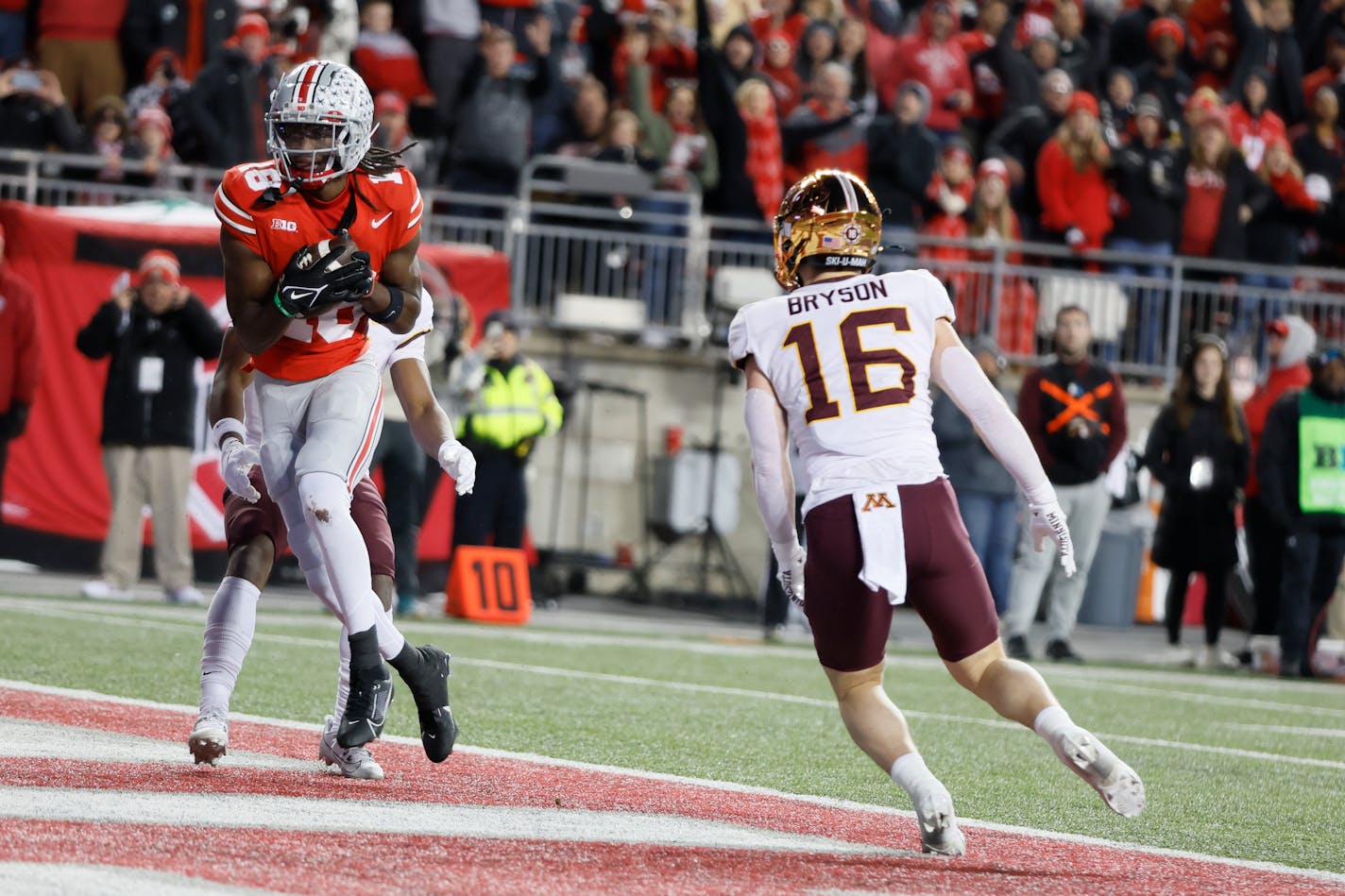 Ohio State receiver Marvin Harrison, left, scores a touchdown as Minnesota defensive back Coleman Bryson (16) defends during the second half of an NCAA college football game Saturday, Nov. 18, 2023, in Columbus, Ohio. (AP Photo/Jay LaPrete)