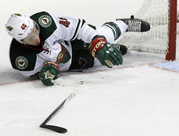 Minnesota Wild defenseman Jared Spurgeon (46) lays on the ice after he was hit with a stick during the third period of an NHL hockey game against the 