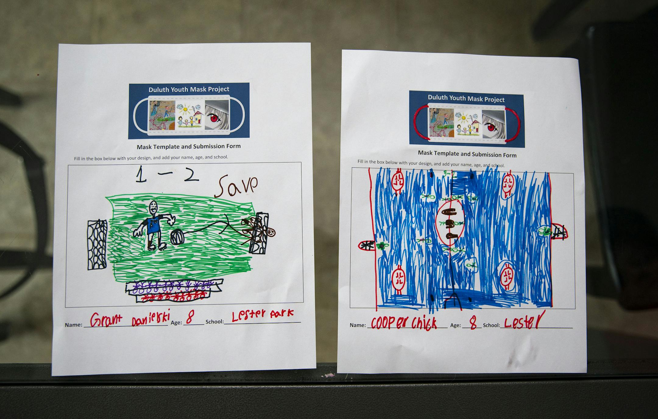The two finished designs for masks by Grant Danielski (8) and Cooper Chick (8) sat on Cooper's kitchen table. ] ALEX KORMANN • alex.kormann@startribune.com The City of Duluth is asking local kids to draw and color face mask designs at home. A few of the best ones will be selected to be printed on real masks that will be handed out in the community.