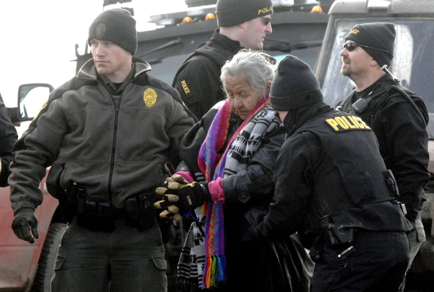 An elderly woman is escorted to a transport van after being arrested by law enforcement at the Oceti Sakowin camp as part of the final sweep of the Dakota Access pipeline protesters in Morton County, Thursday, Feb. 23, 2017, near Cannon Ball, N.D.