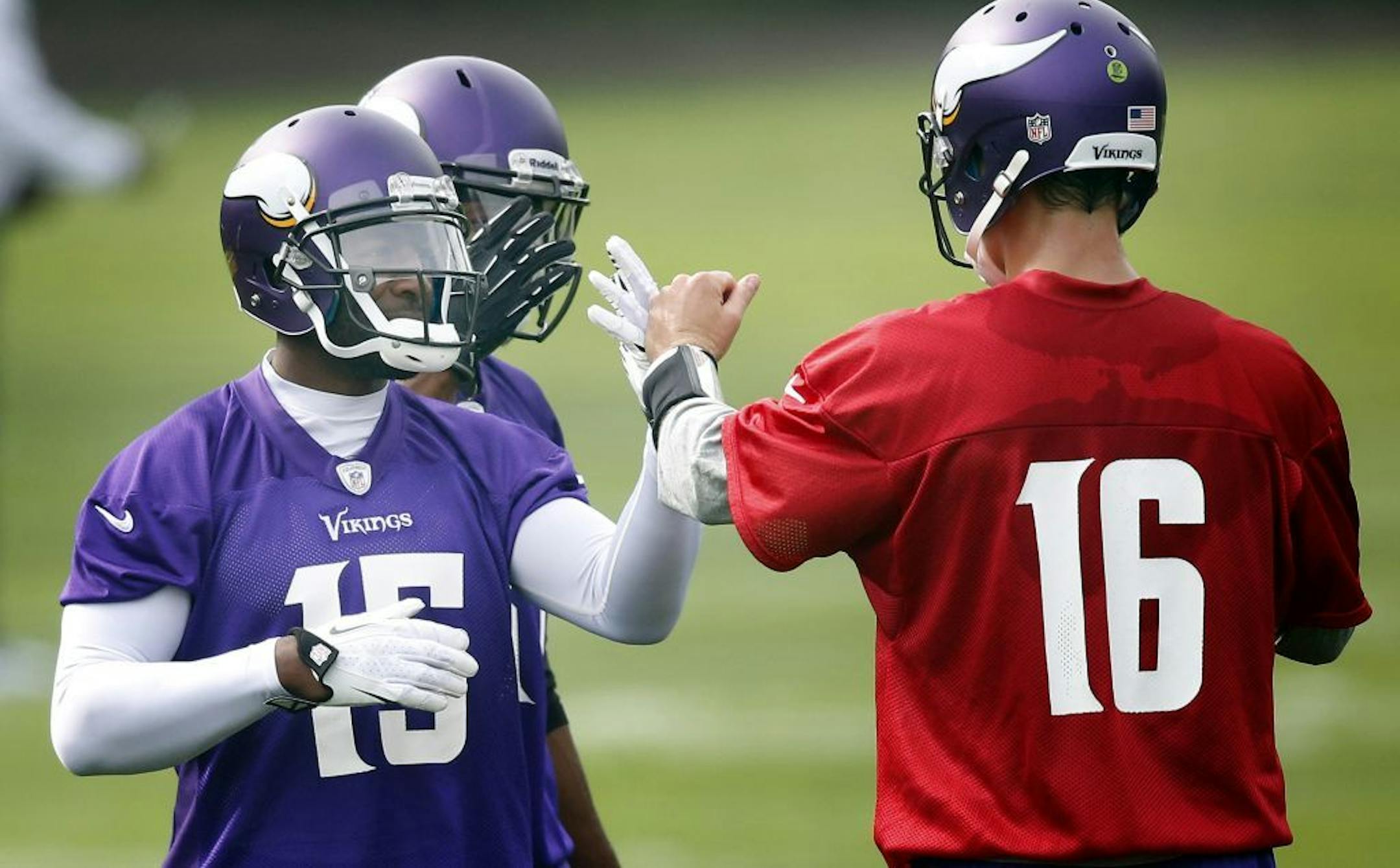 Minnesota Vikings receiver Greg Jennings (15) was greeted by quarterback Matt Cassel (16) during practice on Wednesday at The Grove in Watford, England.
