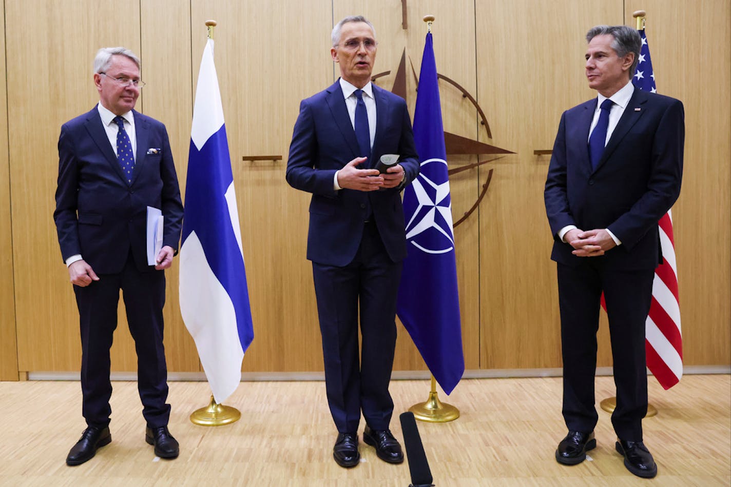 NATO Secretary General Jens Stoltenberg, center, speaks as Finland's Foreign Minister Pekka Haavisto, left, prepares to hand over a document to United States Secretary of State Antony Blinken during a meeting of NATO foreign ministers at NATO headquarters in Brussels, Tuesday, April 4, 2023. Finland is poised to join NATO on Tuesday, a historic realignment triggered by Russia's invasion of Ukraine. (Johanna Geron, Pool Photo via AP)