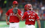 Texas Rangers starting pitcher Yu Darvish and catcher Chris Gimenez meet on the mound during the second inning against the Minnesota Twins on Saturday
