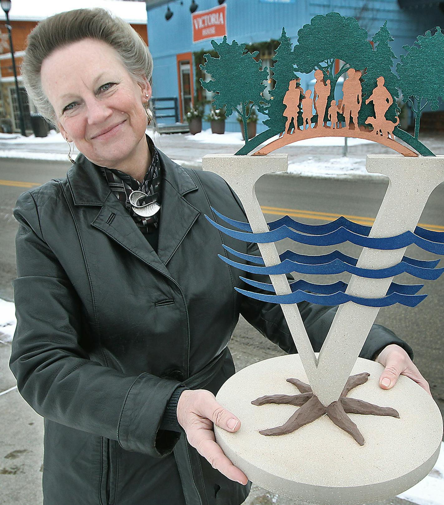 Local artist, Deb Zeller donated hours to create a sculpture that will be placed near downtown Victoria in the Spring during a celebration. Here Zeller held up a model near the spot where it will stand, Thursday, January 21, 2016 in Victoria, MN. ] (ELIZABETH FLORES/STAR TRIBUNE) ELIZABETH FLORES &#x2022; eflores@startribune.com