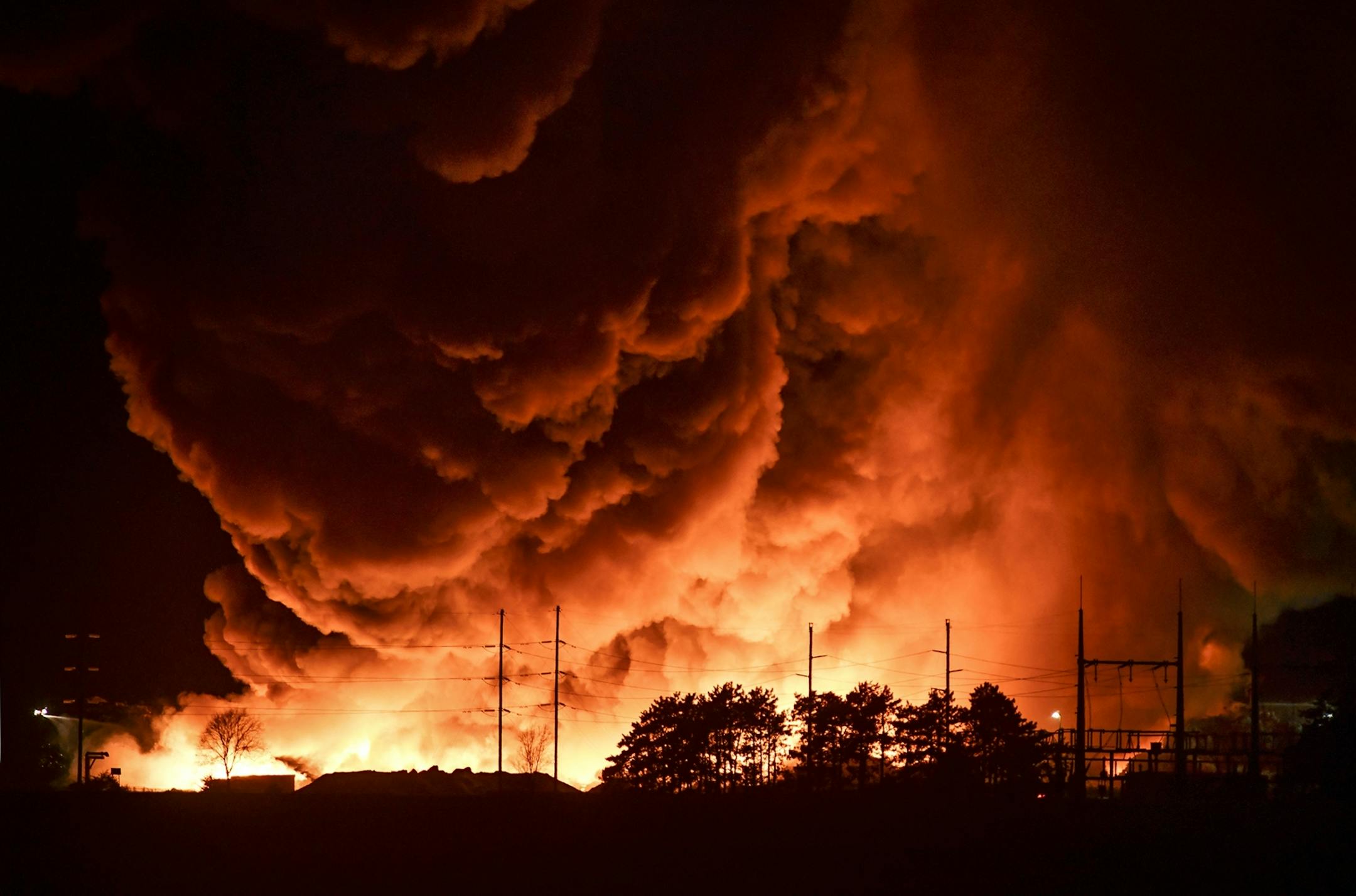 Flames and smoke tower into the sky at the Northern Metal Recycling plant Wednesday, Feb. 19, 2020, in Becker, Minn. A passerby first spotted the fire about early Tuesday, the St. Cloud Times reports. Investigators believe that the fire at the Northern Metal Recycling plant in Becker could last several more days.