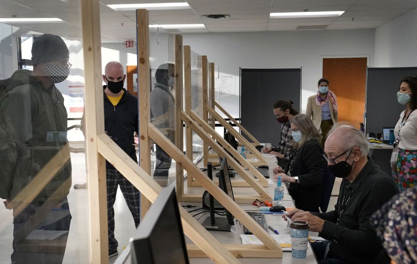 Protective barriers give safety to early voting for voters and poll workers at Minneapolis Elections and Voter Services Friday in Minneapolis.