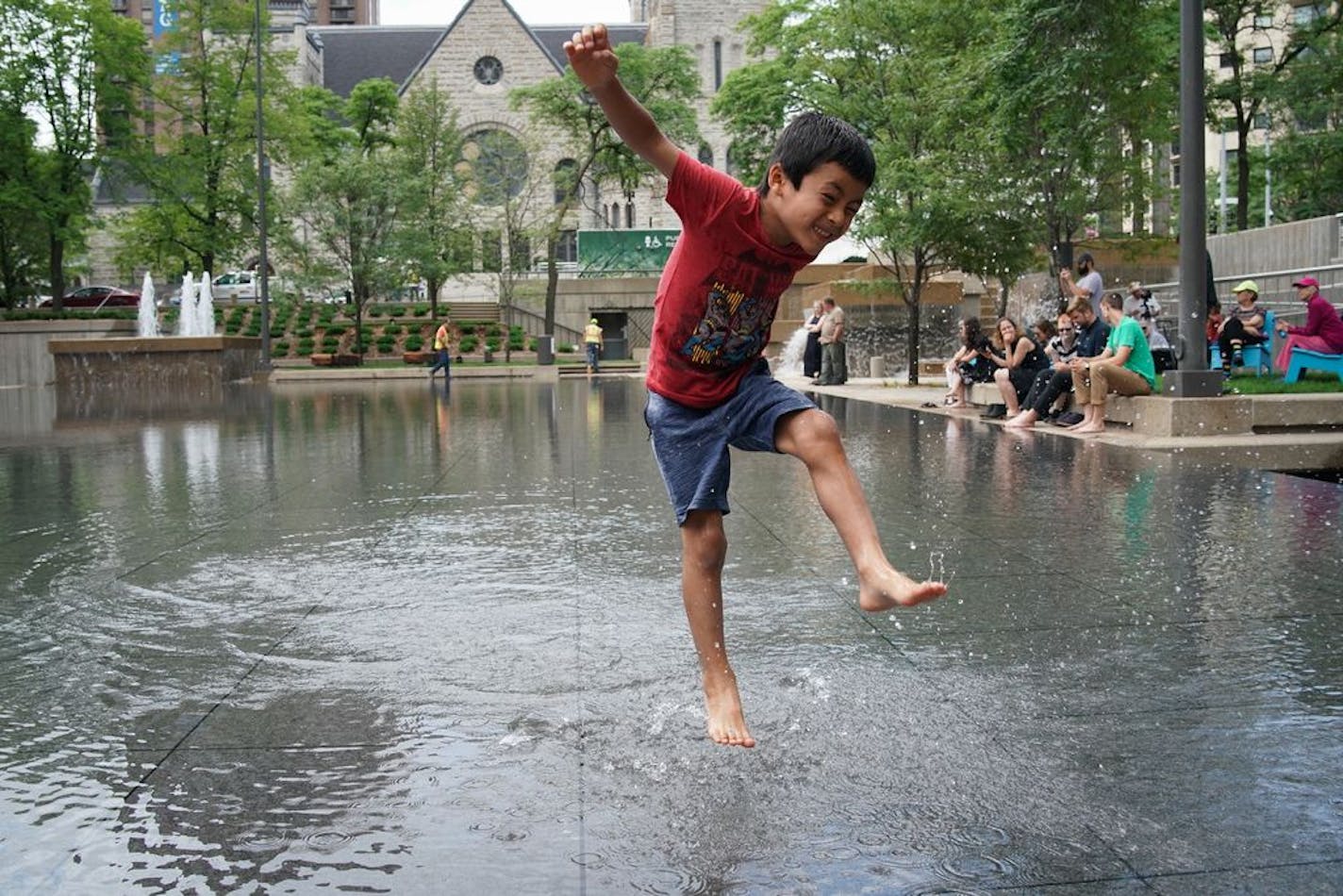 After renovations, Peavey Plaza in downtown Minneapolis was given a grand re-opening, which included running the water fountains and filling the reflecting pool which have been dry for years. Here, 6-year old Tenzin Thutop from Minneapolis played in the reflecting pool.