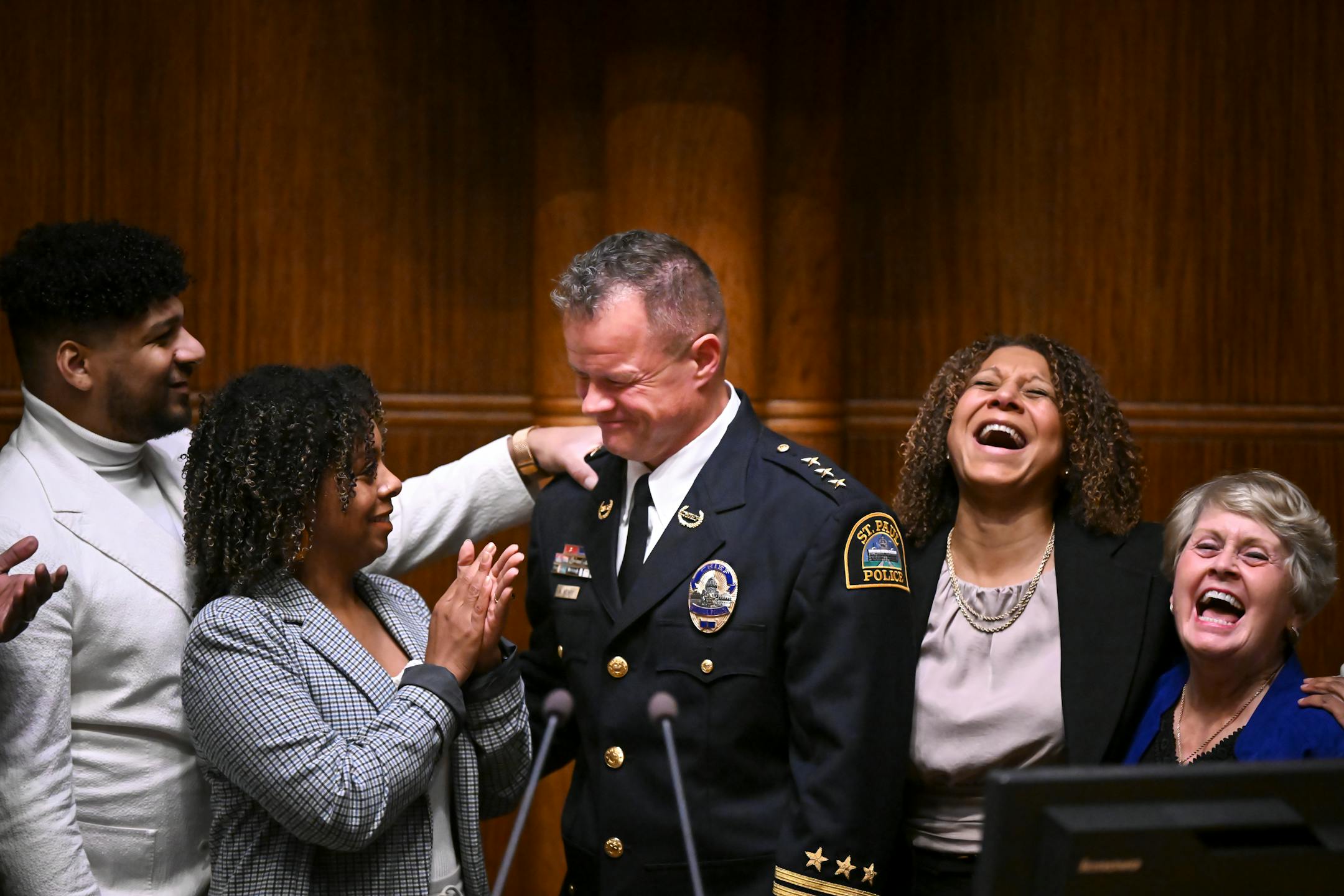 Newly-confirmed St. Paul Police Chief Axel Henry is surrounded by celebrating family after the City Council unanimously confirmed his as the new chief Wednesday, Nov. 16, 2022 at St. Paul City Hall in St. Paul, Minn.. To his right, partner Mikeya Grifin.