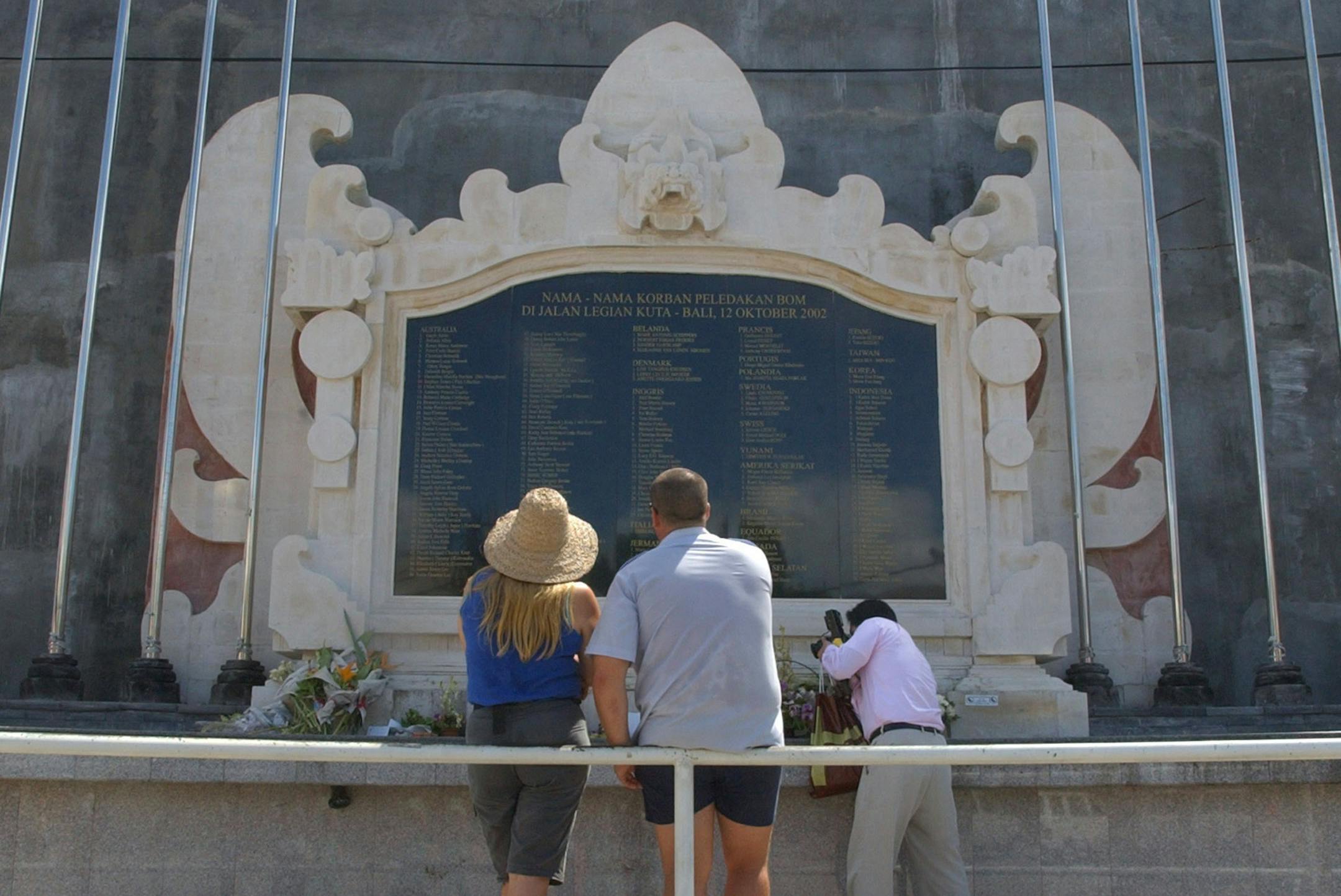 **FOR IMMEDIATE RELEASE** Visitors to the Bali bombing memorial look at the names of the victims and take photos, April 17, 2004, in Kuta Beach Bali, Indonesia. The memorial commemorates the over 200 people who died in the Oct. 12, 2002 nightclub bombings. (AP Photo/Suzanne Plunkett)