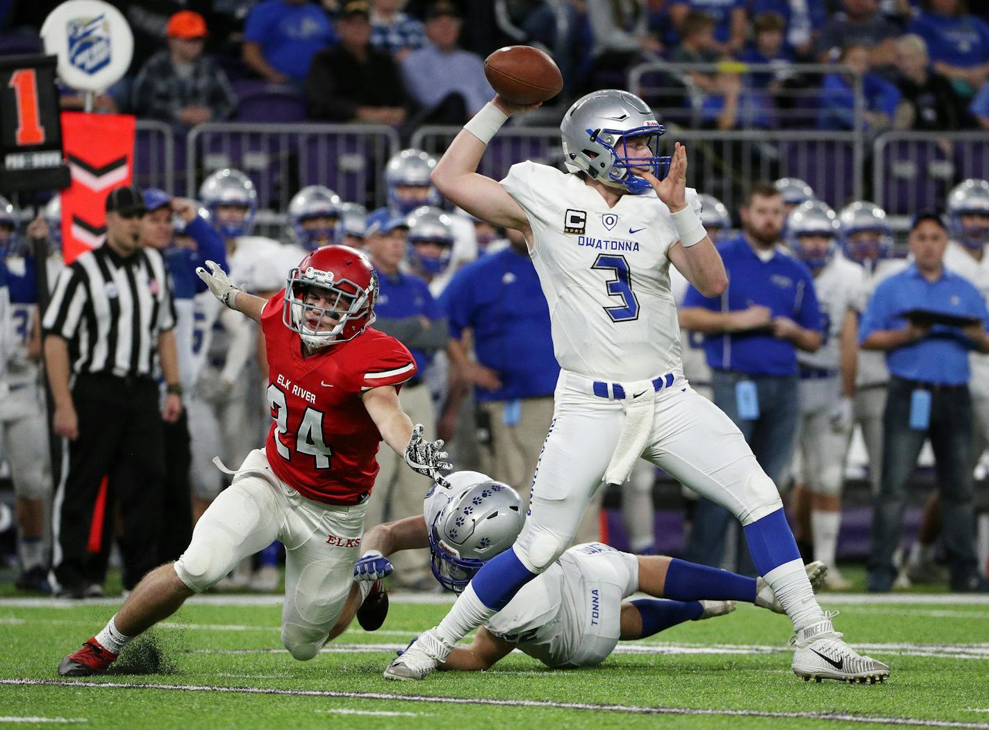 Owatonna High School quarterback Abe Havelka (3) made a pass under pressure as Elk River High School running back Collin Nelson (24) leapt past Owatonna High School running back Jason Williamson (22) in the first half. ] ANTHONY SOUFFLE &#xef; anthony.souffle@startribune.com Game action from a Class 5A championship football game between Owatonna High School and Elk River High School Saturday, Nov. 25, 2017 at U.S. Bank Stadium in Minneapolis.