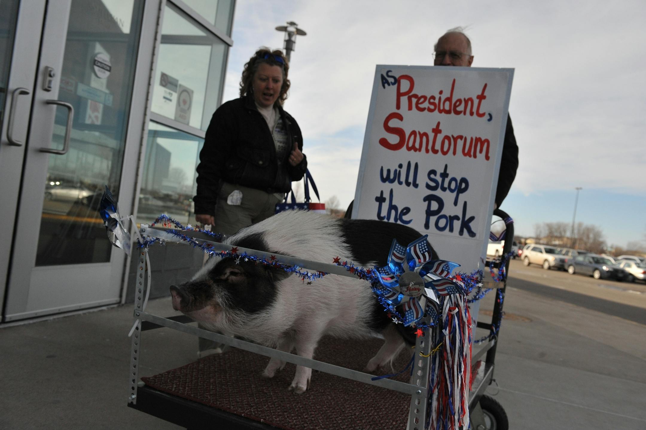 Rick Santorum supporters Marjorie Hosten of Maple Grove came to Santorum's campaign event in Blaine, Tuesday, Feb. 7, 2012 with her dad Ted and pig Taylor Swine.