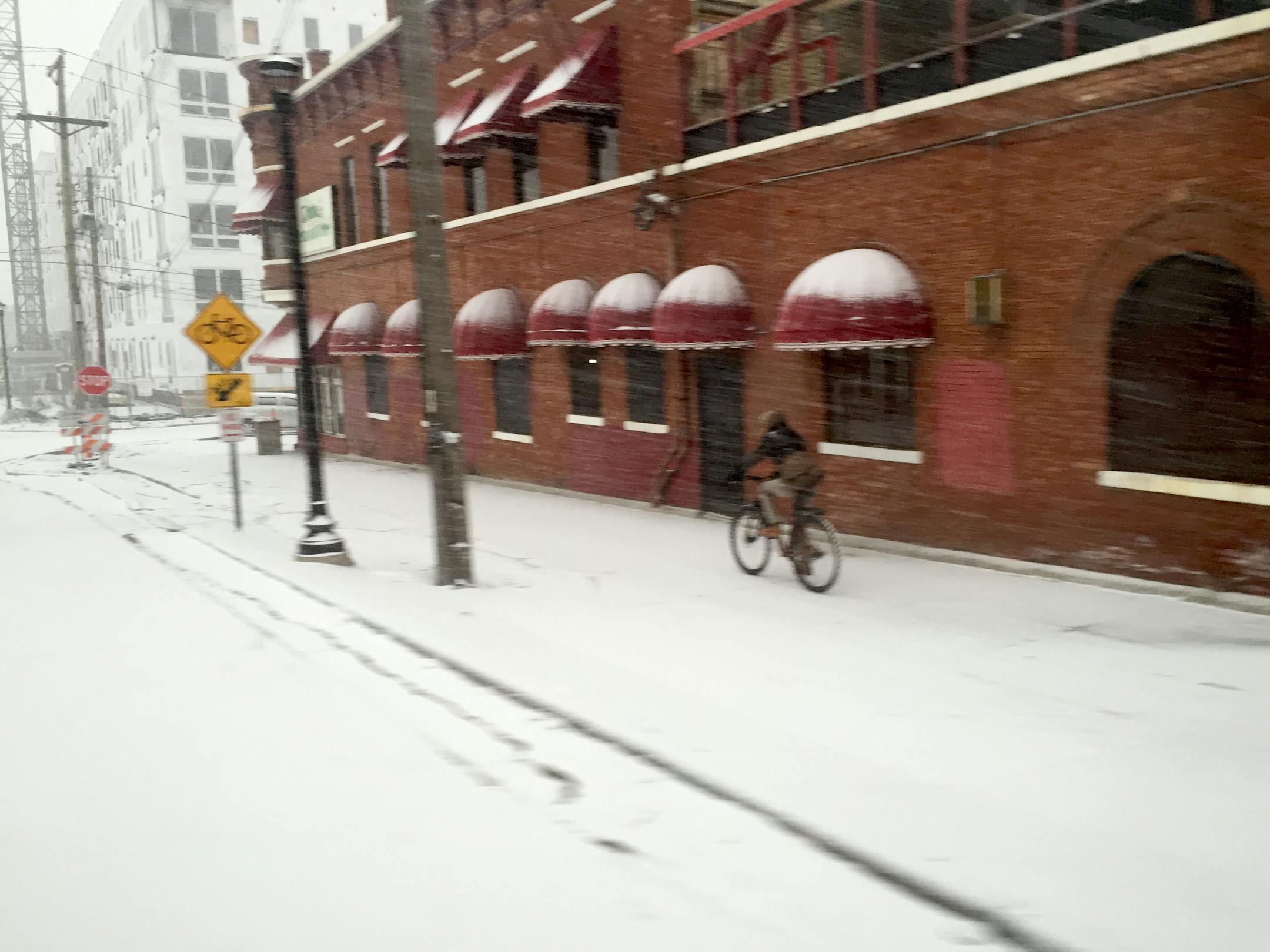 A bicyclist heading northbound on the light rail bike path near the Cedar-Riverside station faced the first dump of early morning snow from a storm that was expected to dump 1-3 inches in the Twin Cities Tuesday, Mar. 3, 2015.