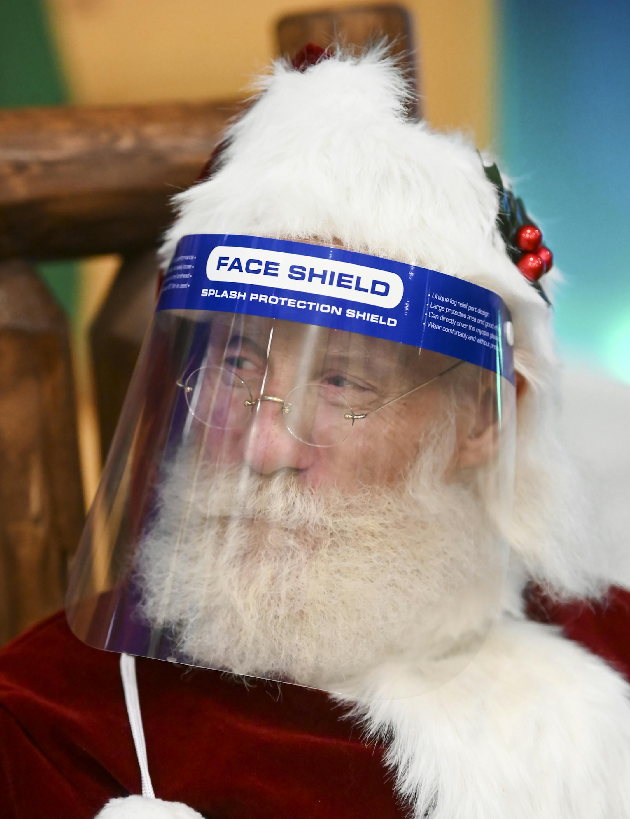 "Santa Scott," of Minneapolis, wore a face shield and was separated from families by a large plexiglass barrier. ] AARON LAVINSKY • aaron.lavinsky@startribune.com Cabela's "Santa's Wonderland" looked different this year as visitors had their temperatures checked and were separated from Santa with a regularly-cleaned plexiglass barrier due to the COVID-19 pandemic. Despite the changes, families stopped by in reserved time slots to have their photos taken at the company's Woodbury store on Wednesd