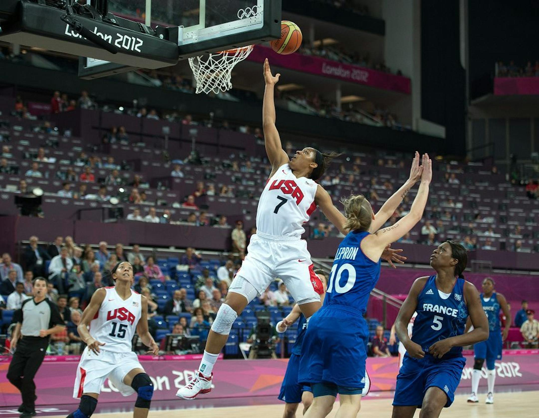 Maya Moore glides to the basket over France players during Team USA's gold gedal basketball game during the 2012 Summer Olympic Games in London.