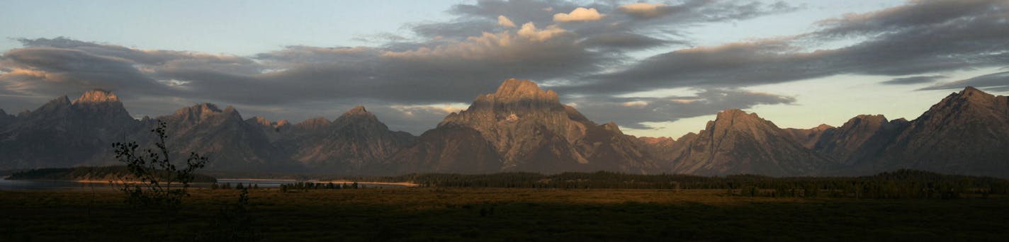 The sun begins to light the Teton Mountains at sunrise, as seen from the Jackson Lake Lodge Saturday, Sept. 1, 2007, at Grand Teton National Park, Wyoming. (AP Photo/Ted S. Warren) ORG XMIT: WATW105