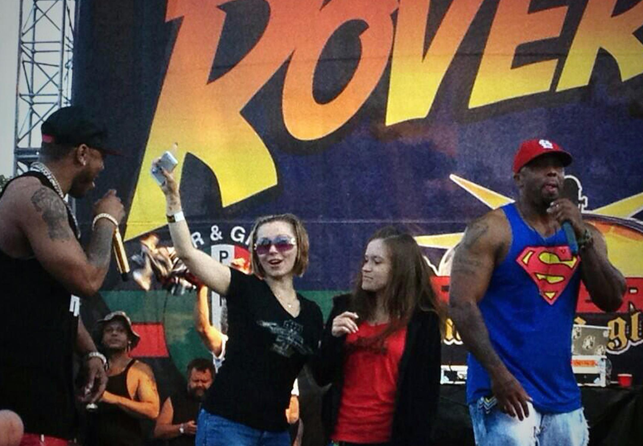 In this Saturday, July 27, 2013, photo provided by Brian Harrell, Amanda Berry, one of three women held captive in a Cleveland home for a decade, makes a surprise appearance at the RoverFest concert in Cleveland. Berry appeared at a public event for the first time since her rescue, a day after her abductor pleaded guilty in the case. The rapper Nelly called Berry back to the stage after his music set. (AP Photo/Courtesy Brian Harrell)