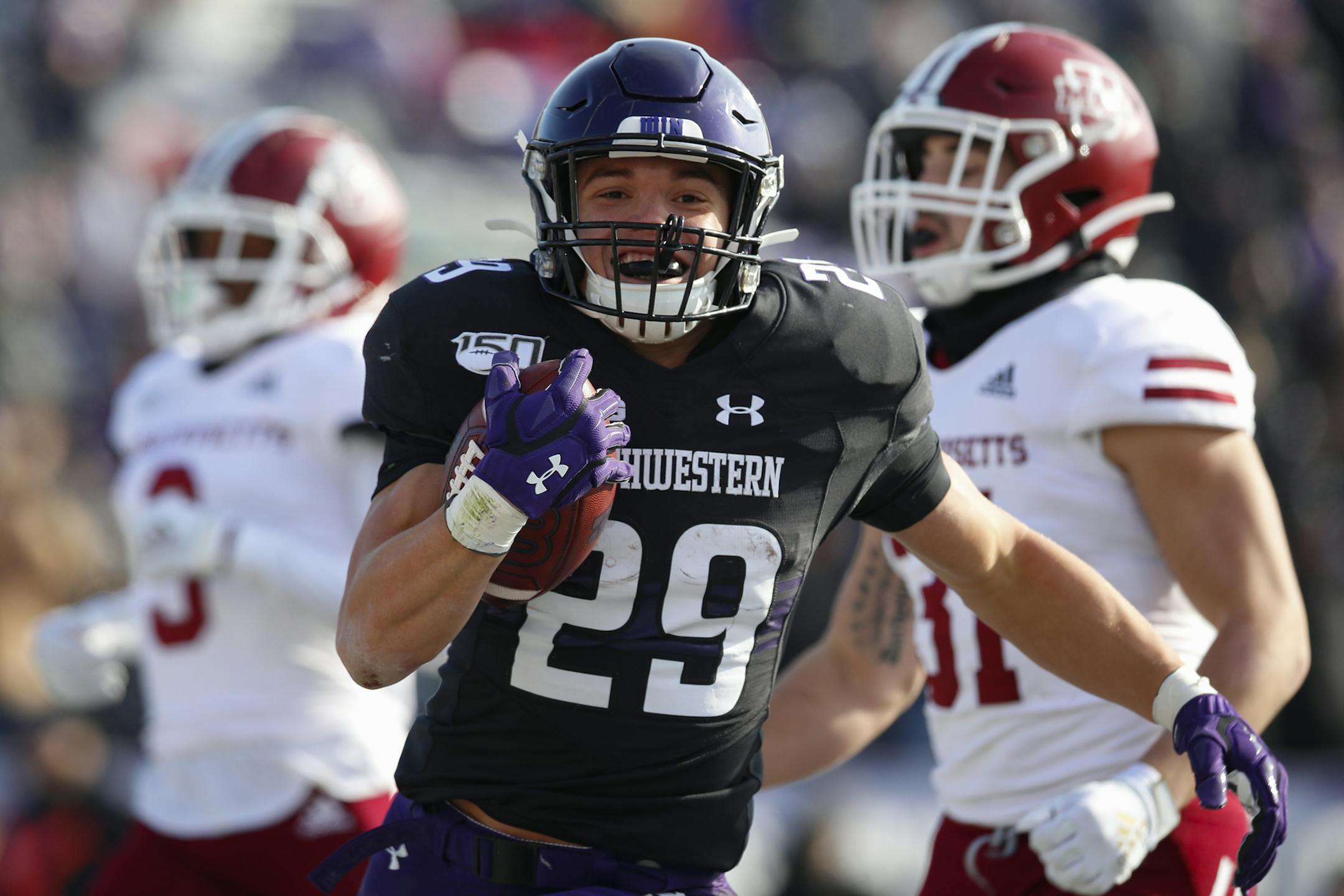 Northwestern's Evan Hull, center, celebrates as he scores a touchdown past Massachusetts' Isaiah Rodgers, left, and Massachusetts' Logan Darby during the first half of an NCAA college football game Saturday, Nov. 16, 2019, in Evanston, Ill. (AP Photo/Jim Young)