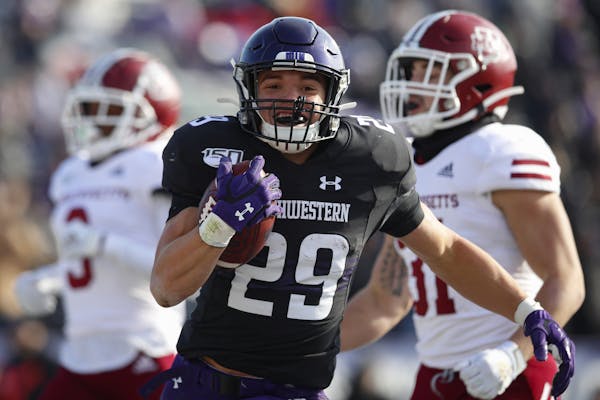 Northwestern's Evan Hull, center, celebrates as he scores a touchdown past Massachusetts' Isaiah Rodgers, left, and Massachusetts' Logan Darby during 