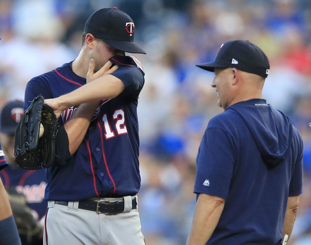 Minnesota Twins starting pitcher Jake Odorizzi (12) talks with pitching coach Wes Johnson during the first inning.
