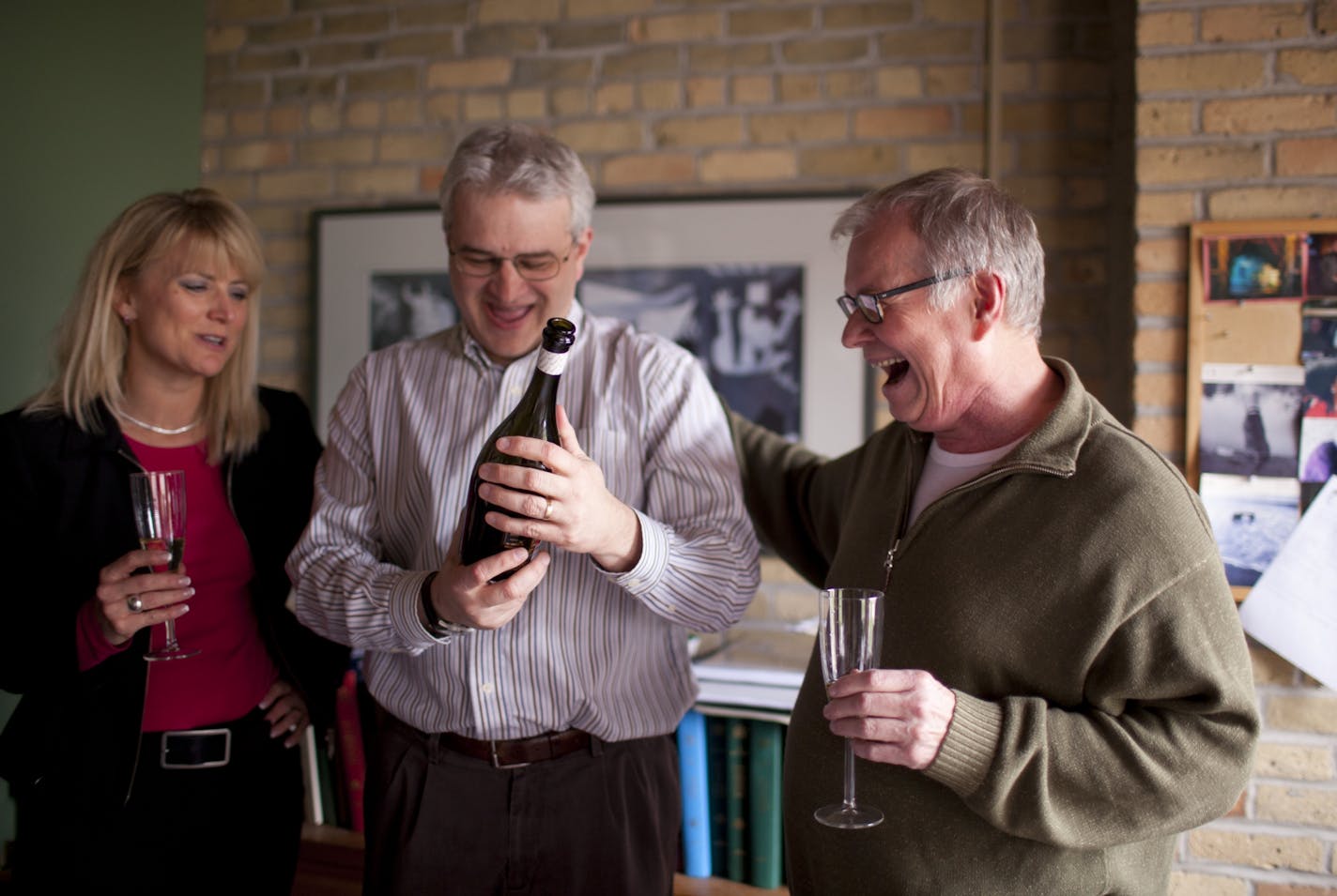 Minnesota Opera Managing Director Kevin Raymach, center, held a bottle of champagne as staffers gathered in the office of Artistic Director Dale Johnson, right, to celebrate the Pulitzer Prize for Music won by Kevin Puts' "Silent Night: Opera in Two Acts," commissioned and premiered by the Minnesota Opera. At left is Executive Assistant Theresa Murray.