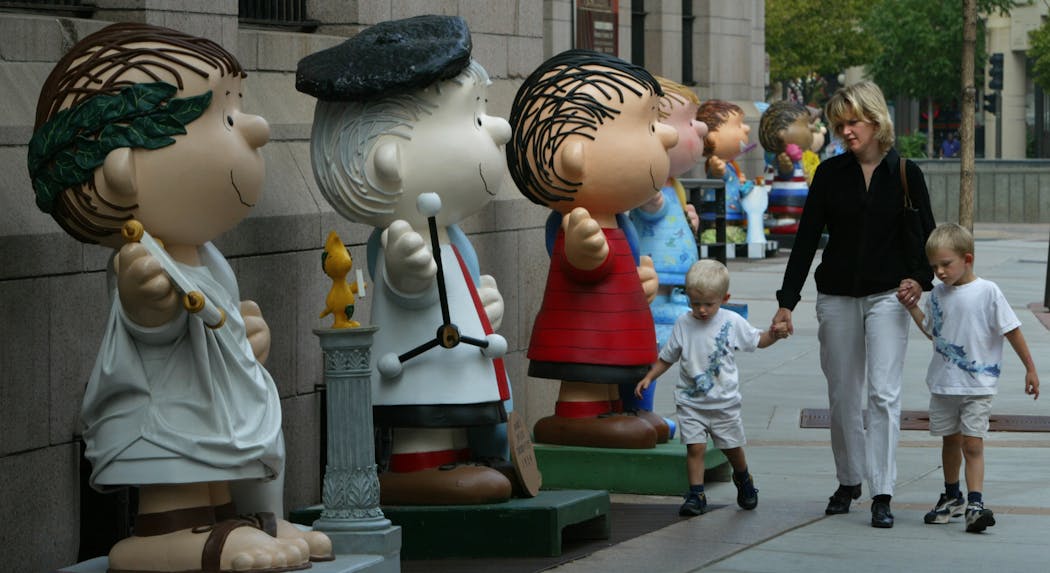 A mother and her children walked past Linus statues outside Landmark Center in St. Paul in 2003.