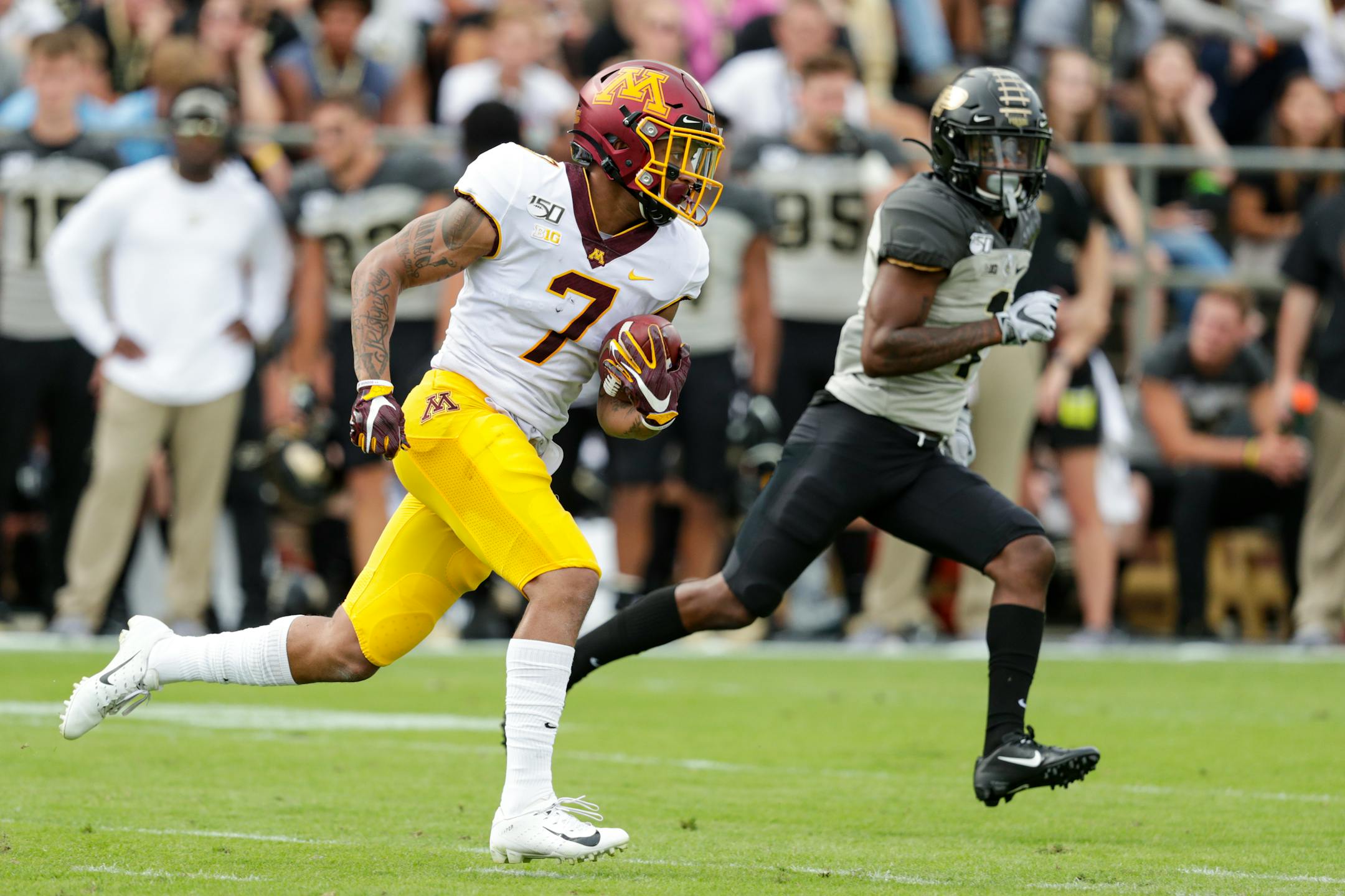 Gophers wide receiver Chris Autman-Bell heads to the end zone past Purdue cornerback Dedrick Mackey after a catch during the first half