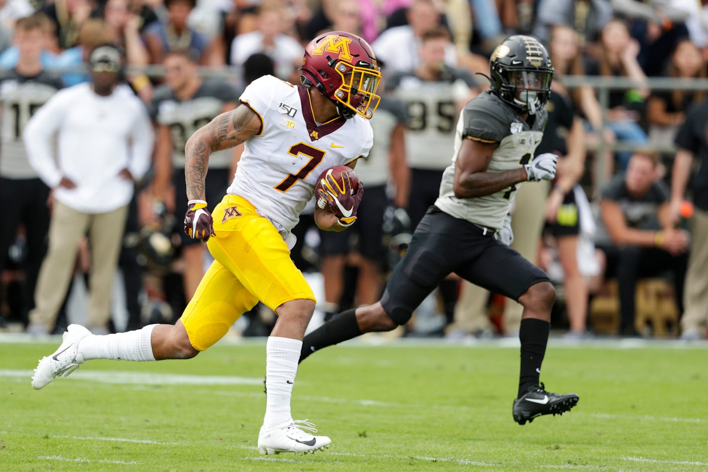 Gophers wide receiver Chris Autman-Bell heads to the end zone past Purdue cornerback Dedrick Mackey after a catch during the first half