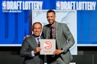 Hawks General Manager Landry Fields, right, and NBA Deputy Commissioner Mark Tatum pose for photos after Tatum announced that the Hawks had won the fi