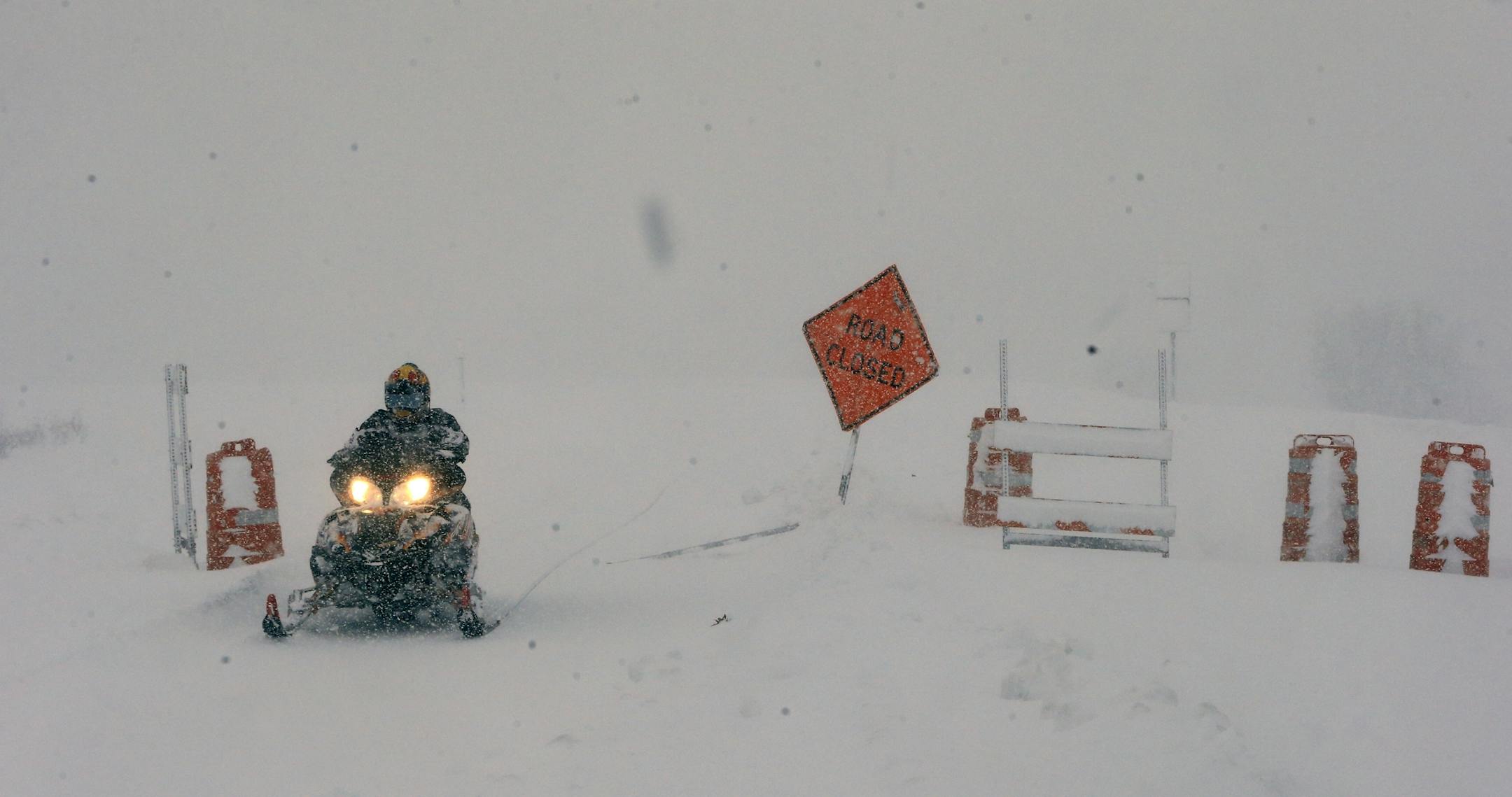 Ron Smolinski makes his way on a snowmobile to his home in Boston, N.Y., after trying to make it to work in Cheektowaga to remove snow, Tuesday, Nov. 18, 2014. Parts of New York measured the season's first big snowfall in feet, rather than inches, on Tuesday as 3 feet of lake-effect snow blanketed the Buffalo area and forced the closure of a 132-mile stretch of the state Thruway. (AP Photo/The Buffalo News, Harry Scull Jr.) TV OUT; MAGS OUT; MANDATORY CREDIT; BATAVIA DAILY NEWS OUT; DUNKIRK OBSE