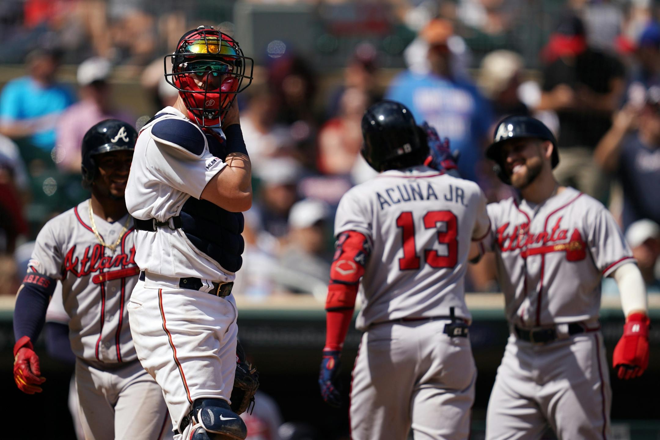 Minnesota Twins catcher Mitch Garver (18) stood at home plate as Atlanta center fielder Ender Inciarte (11) celebrated with right fielder Ronald Acuna Jr. (13) after they both scored in the eighth inning.
