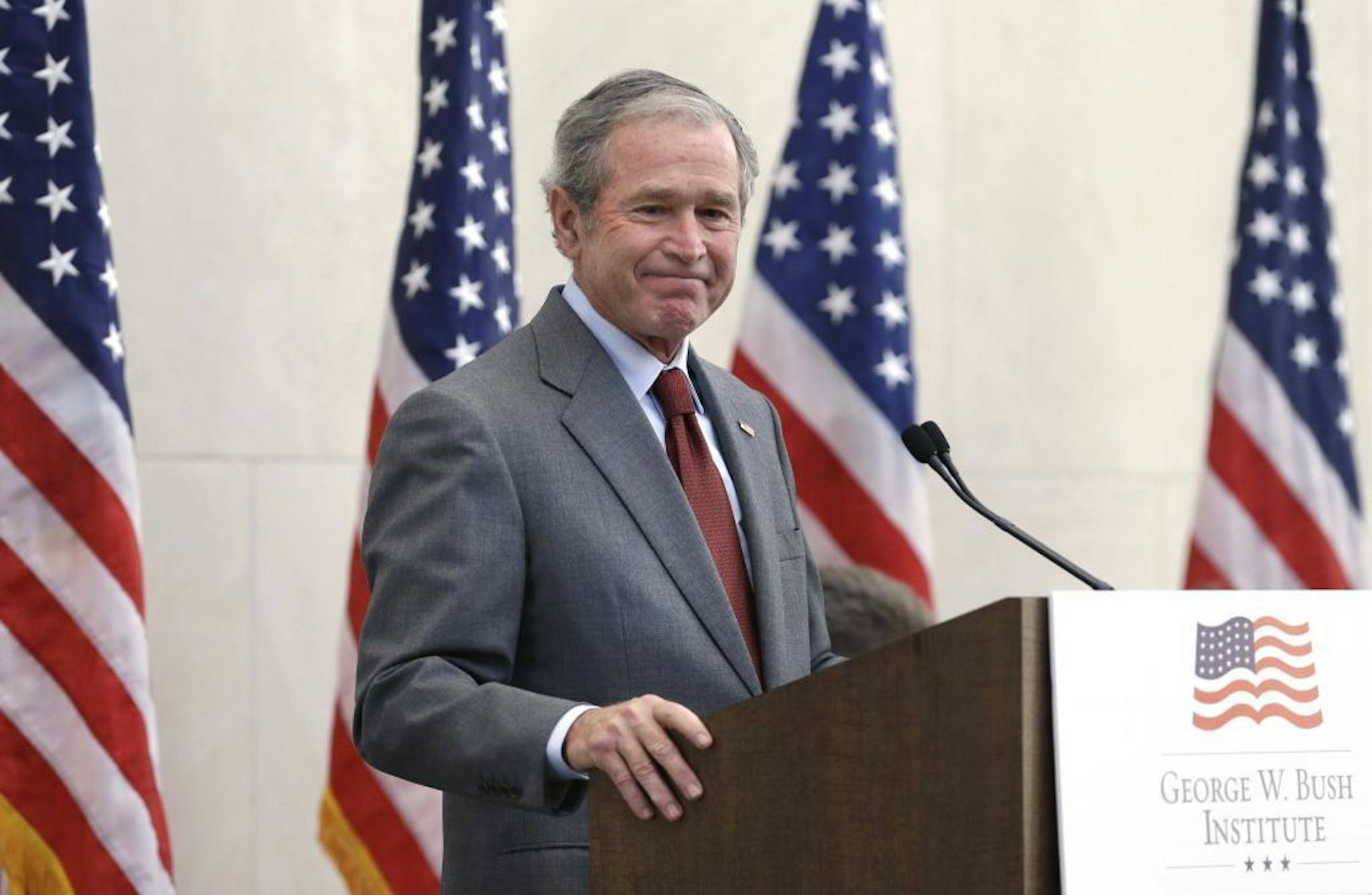 Former President George W. Bush smiles when he concludes a speech before a U.S. citizen swearing in ceremony at the The George W. Bush Presidential Center in Dallas, Wednesday, July 10, 2013. Twenty new citizens took the oath of U.S. citizenship at the former president's library.