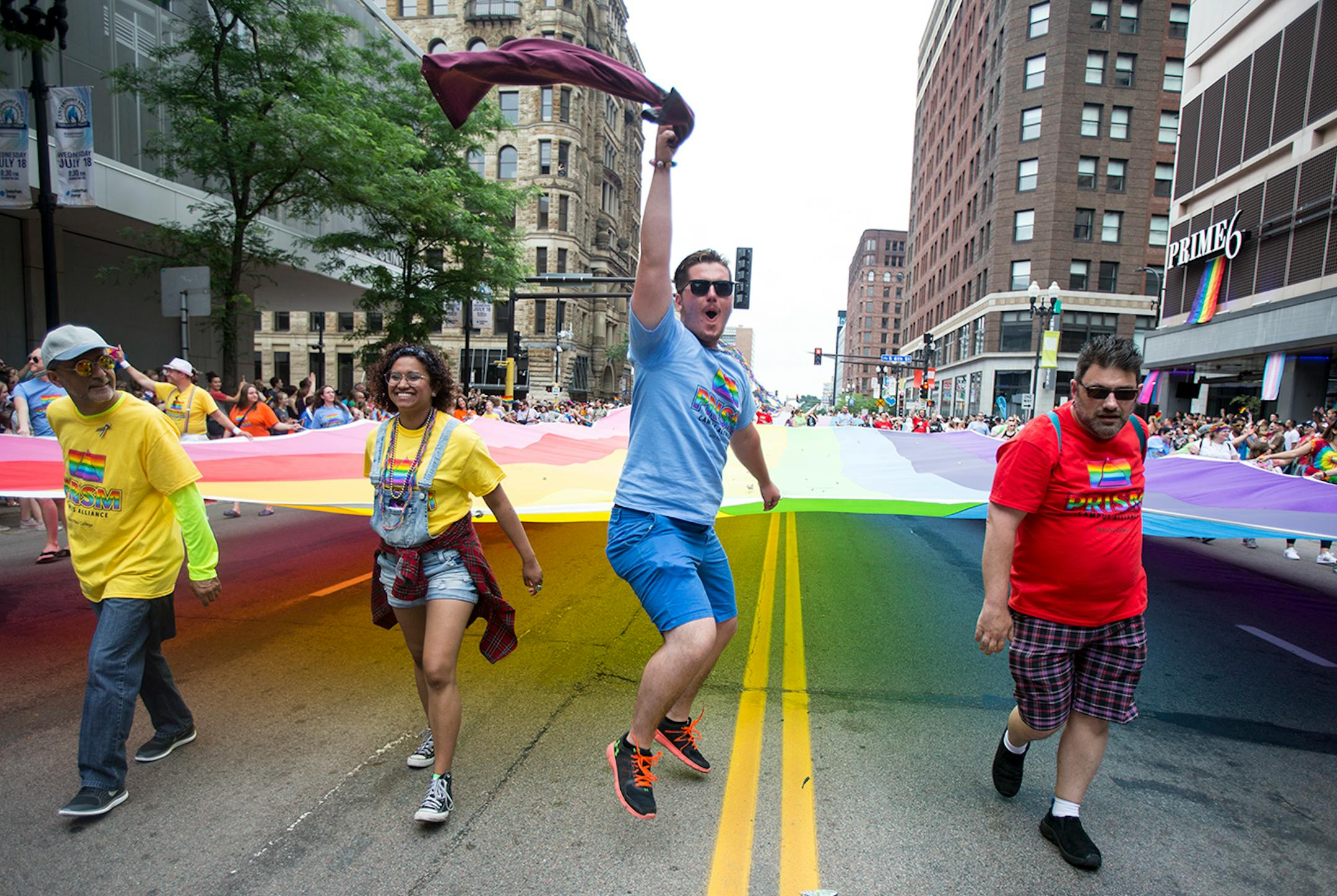 People carrying the pride flag at the helm of the parade get excited as they try to get the crowd cheering during the parade on Sunday.