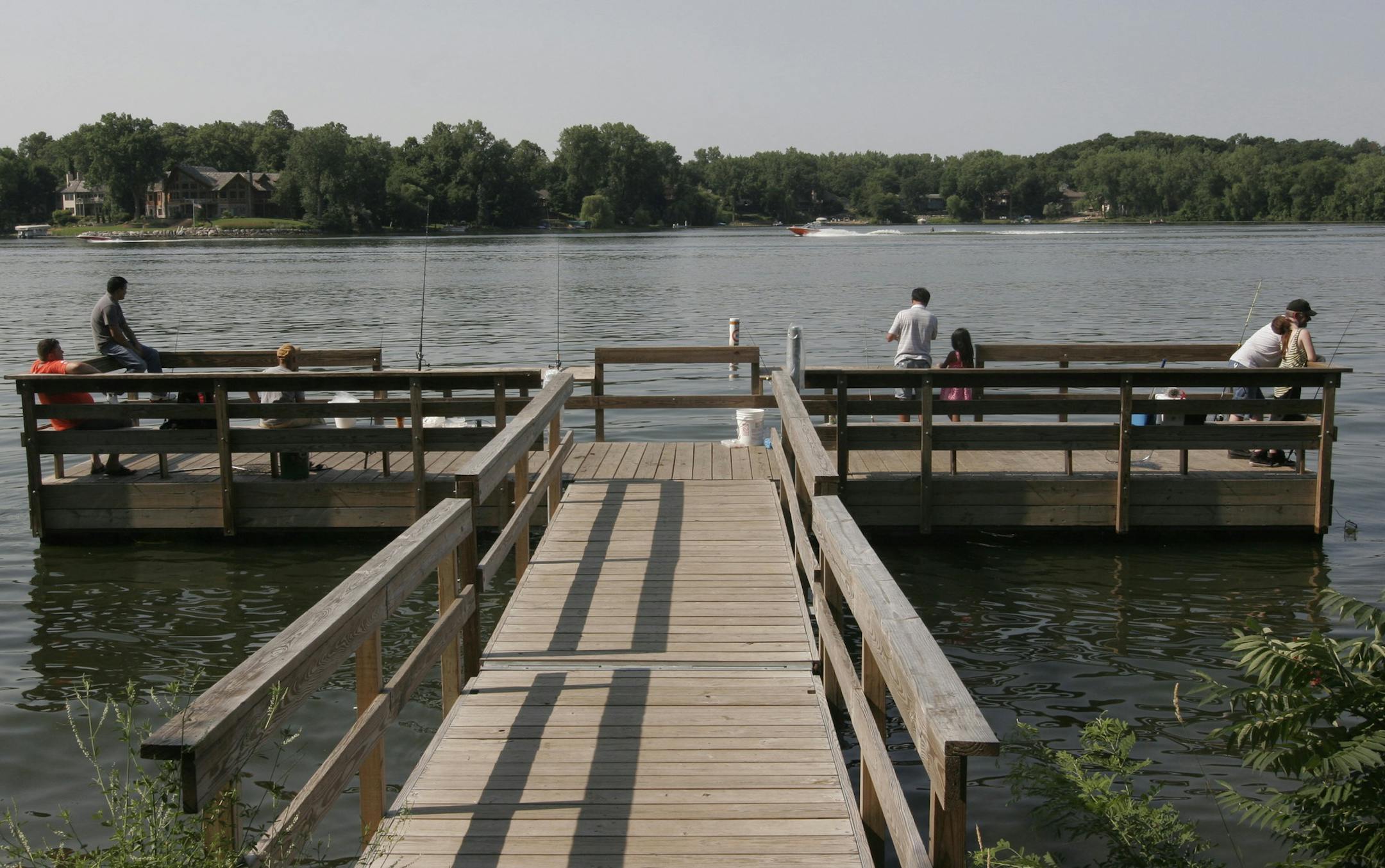 Doug Smith/Star Tribune; July 1, 2012, Crystal Lake, Burnsville. Anglers enjoyed a sparkling summer day over the weekend to fish from a fishing pier at Crystal Lake in Burnsville. The DNR has more than 350 fishing piers, platforms or shore-fishing sites around the state. About one-third are in the Twin Cities area.