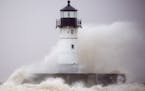 T10.10.2018 -- Steve Kuchera -- 101118.N.DNT.WavesC4 -- A wave dashes itself into spray against the north pier lighthouse at the Duluth harbor entry o