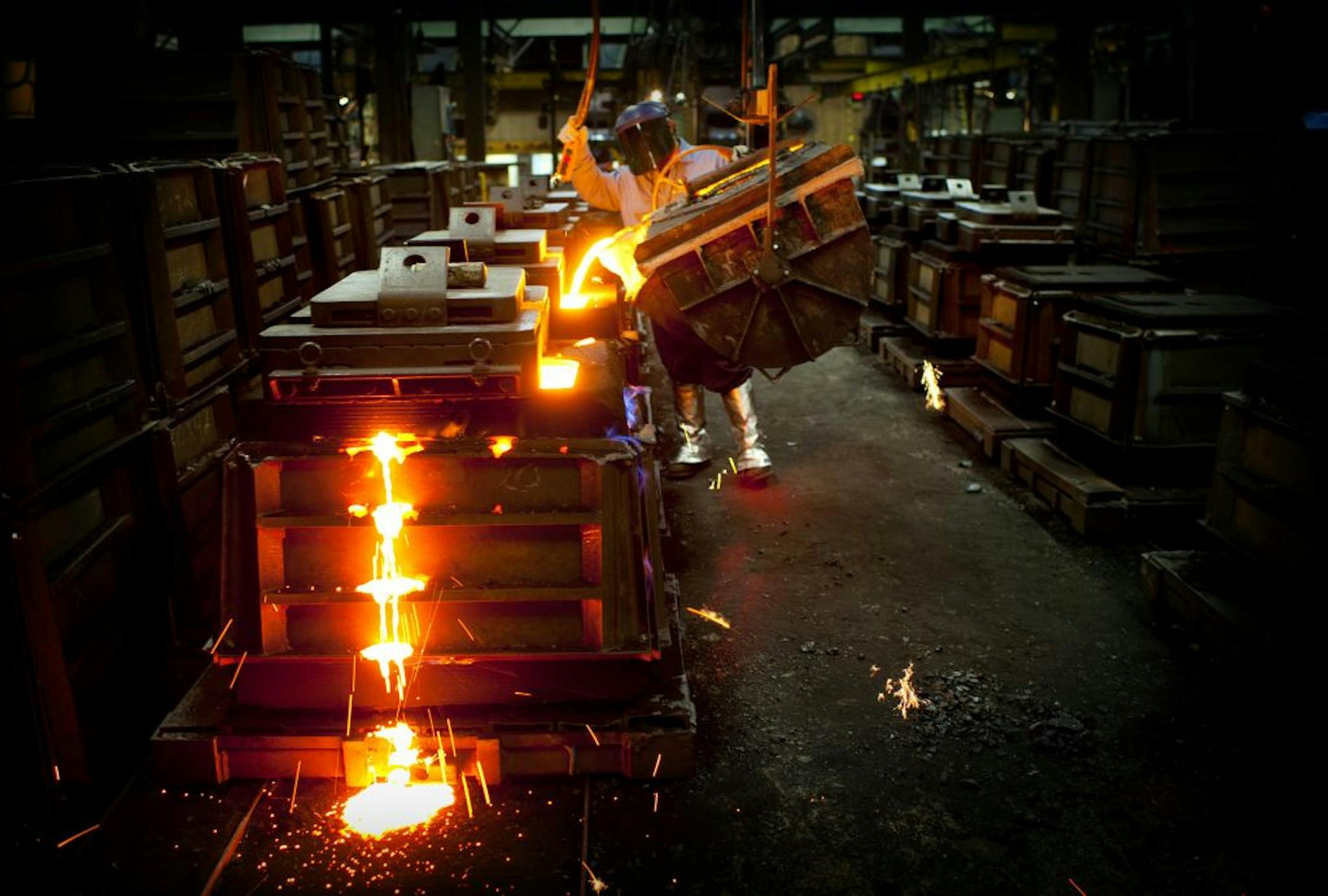 Brandon Smith poured molten iron into sand molds at Badger Foundry in Winona.