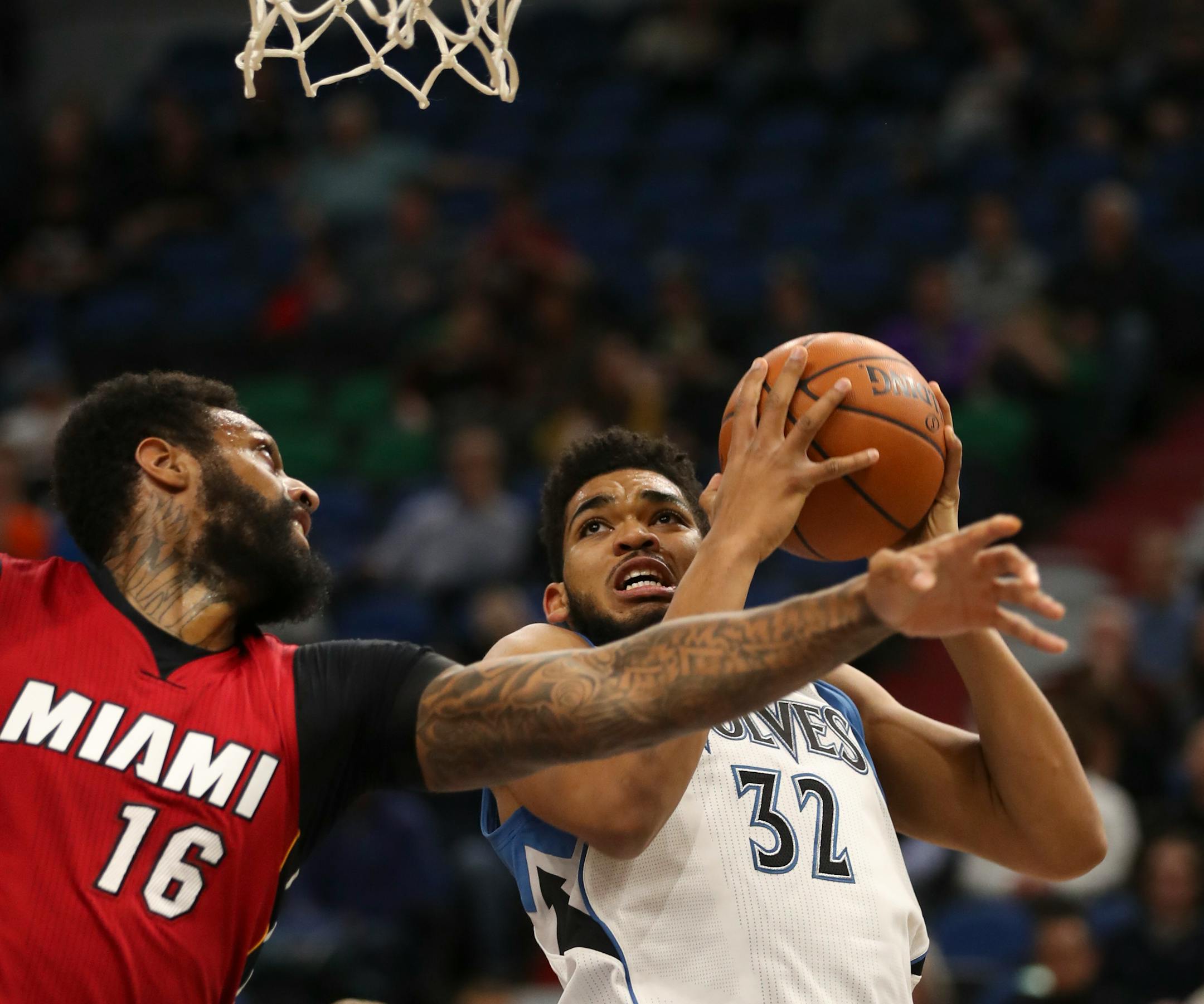 Timberwolves center Karl-Anthony Towns looked for a shot in the first quarter while defended by Heat forward James Johnson.