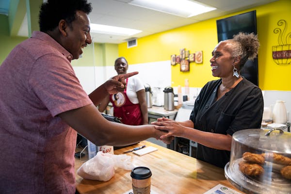 Owner Stephanie Wright talks with State Rep. Samakab Hussein (DFL) while working at Golden Thyme Coffee &amp; Cafe in St. Paul on Thursday, Sept. 7, 2