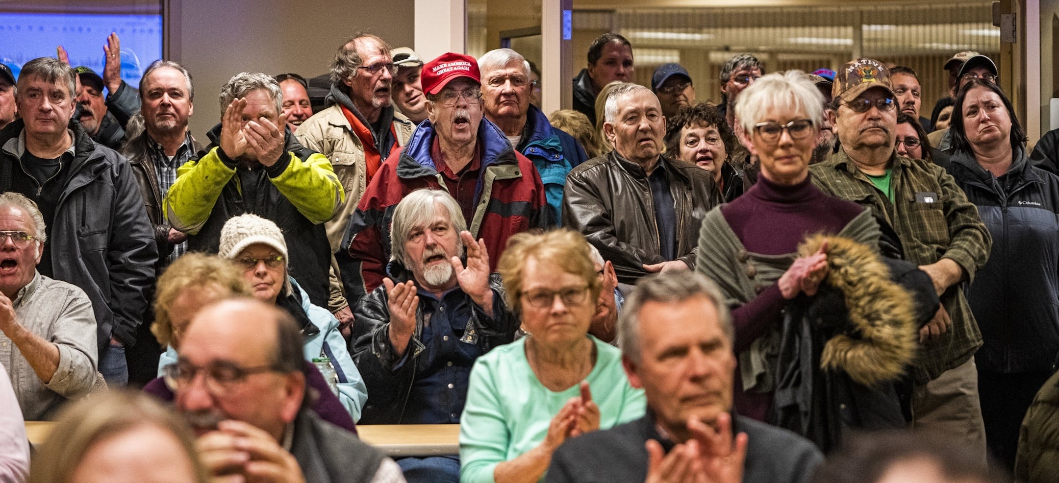 Those in attendance who favored a motion against refugee resettlement stood in the back and made their opinions known.